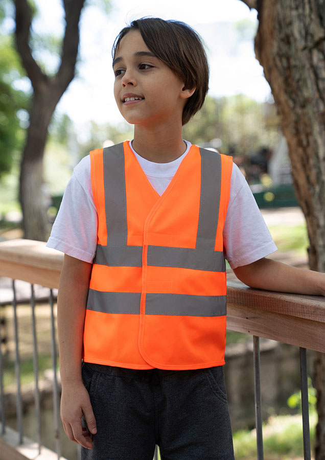Kind trägt eine signal-orange Korntex Warnweste mit vier Reflexstreifen im Alltag, Sicherheitsweste, Warnweste, Reflektiv, Kindergröße, orange, Hi-Vis Weste, Sicherheitsweste, reflektierende Weste, Kind, Orange